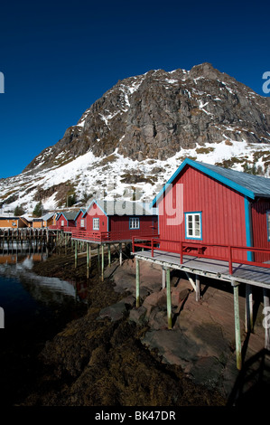 Traditional red wooden fishermen`s Rorbu huts by sea in Tind village in Lofoten Islands in Norway Stock Photo